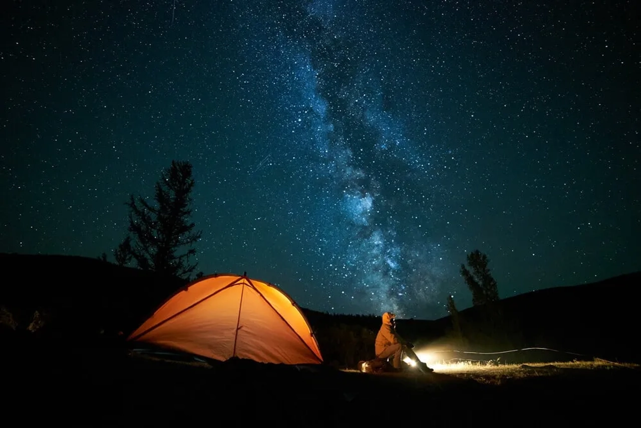 noite estrelada e tenda de campismo laranja