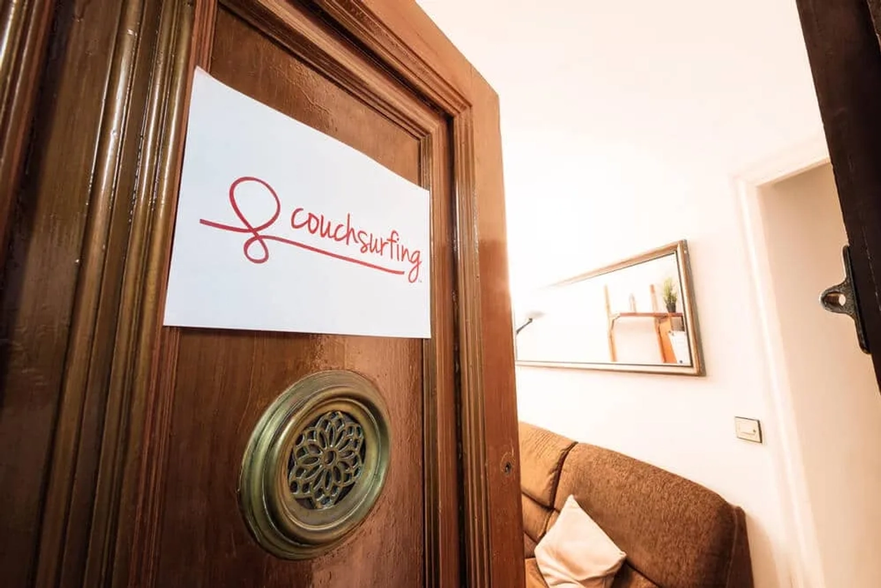 porta entreaberta com placa do couchsurfing
