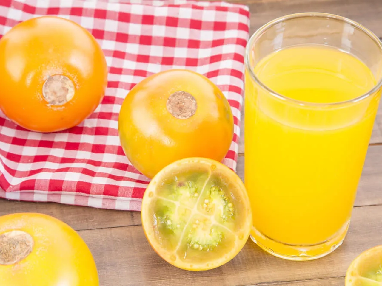 lulo cortado a meio e copo com sumo de lulo