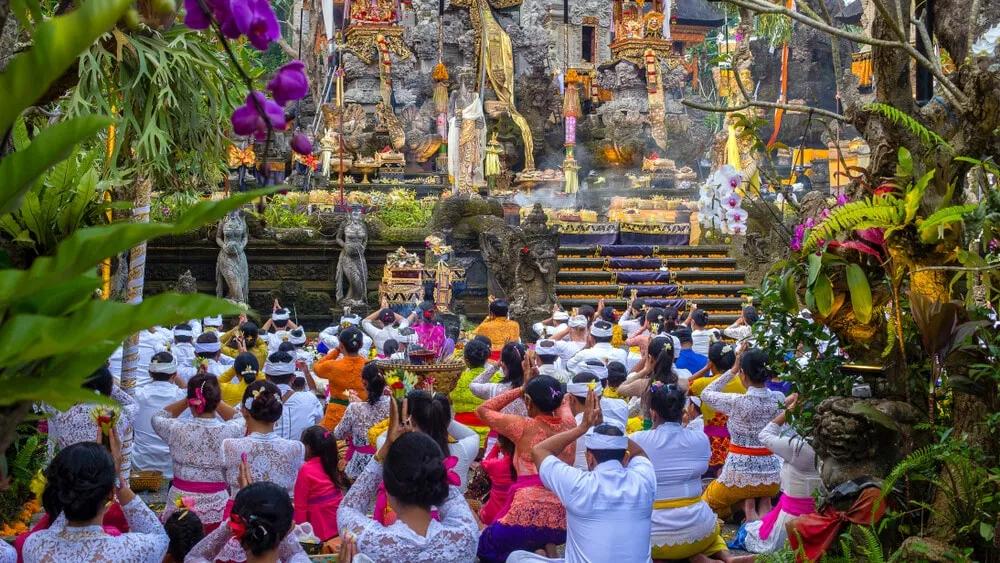 varias pessoas rezam num templo hindu de bali