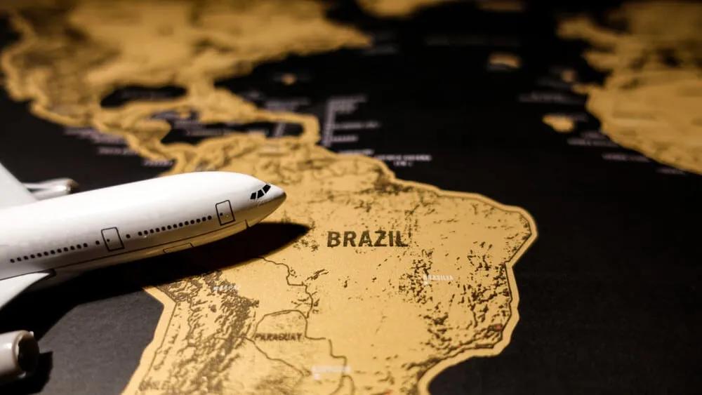 avião sobre mapa dourado do brasil