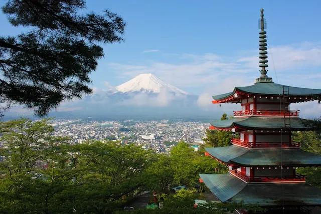 red and green temple in front of a mountain in japan
