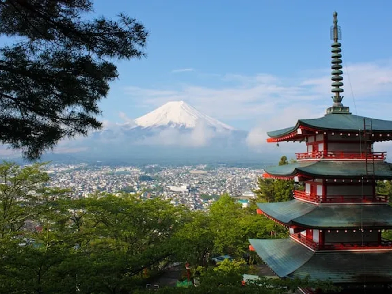 red and green temple in front of a mountain in japan