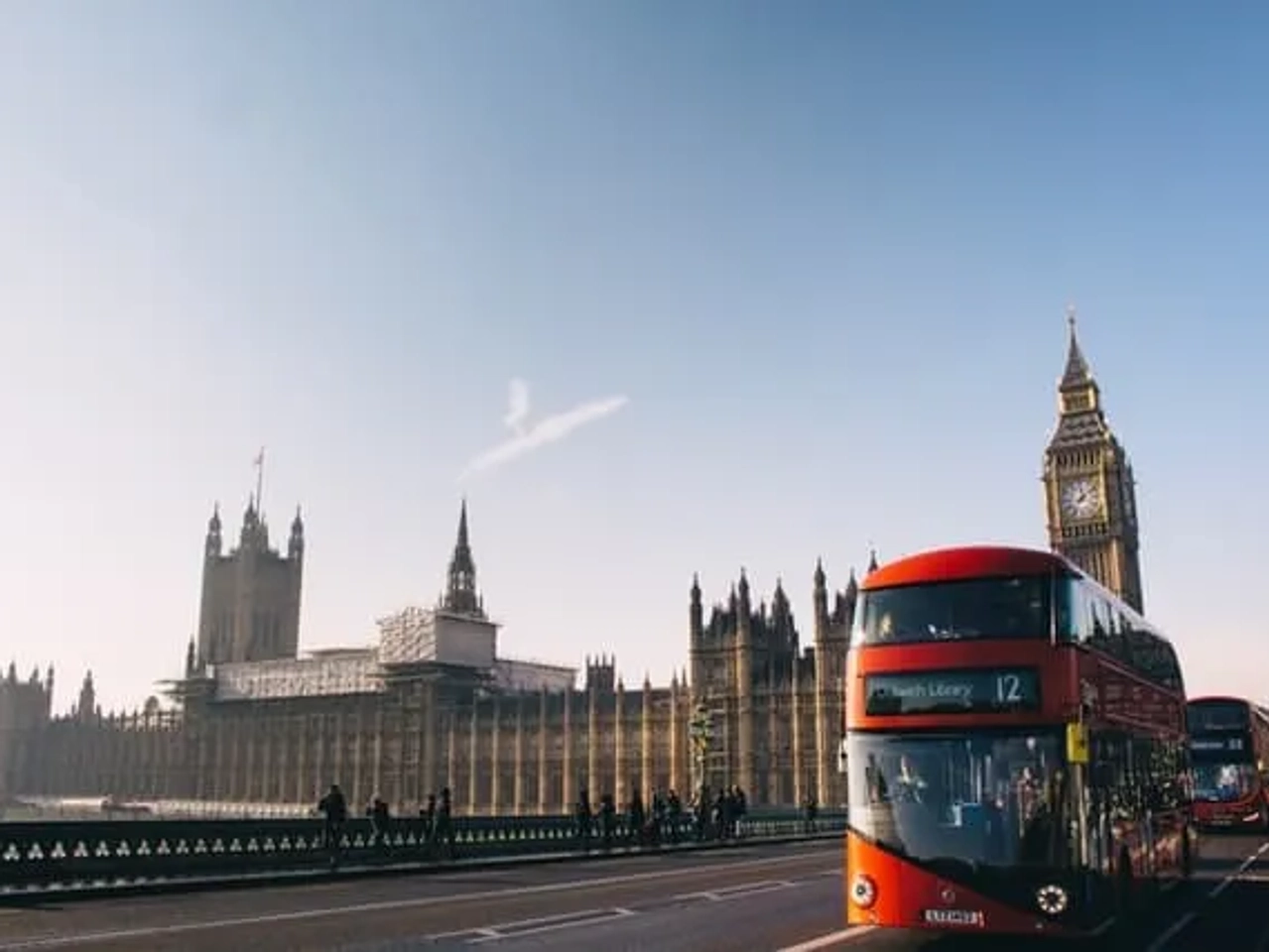 autocarro vermelho a passar ao pé do Palácio de Westminster