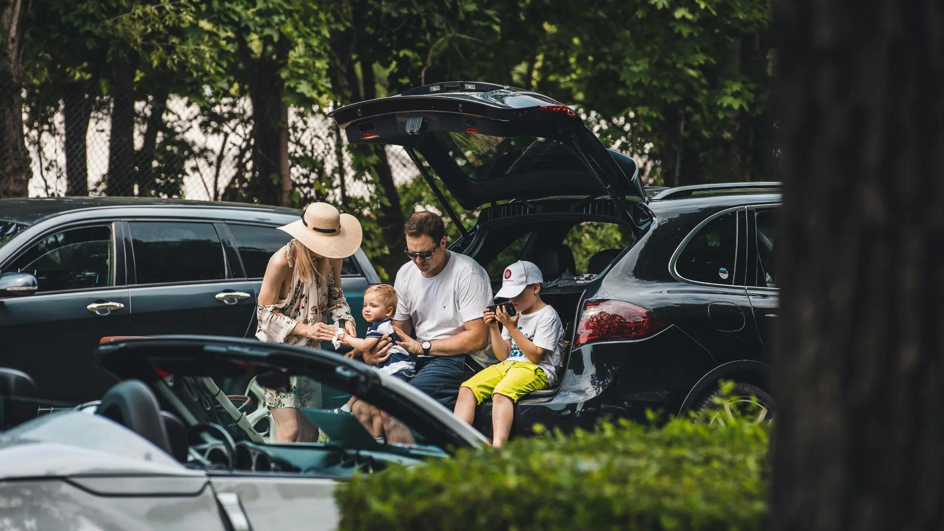 Familia descansando junto a un coche financiado y protegido por un seguro de vida