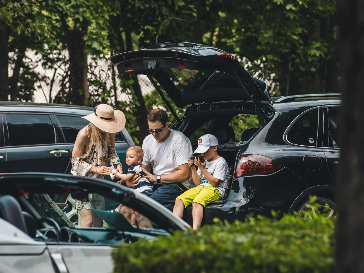 Familia descansando junto a un coche financiado y protegido por un seguro de vida