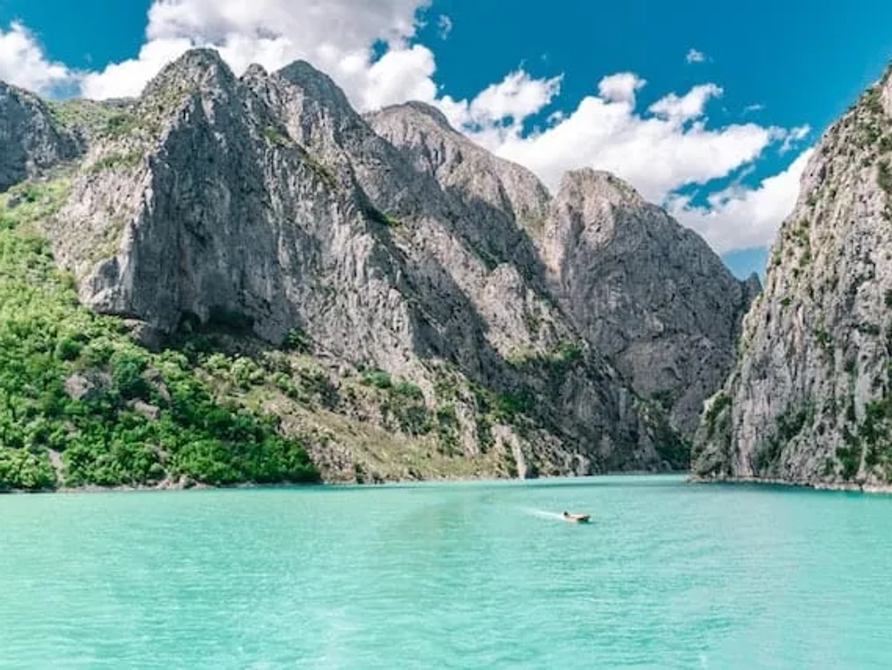 montanhas a volta de um lago de agua azul turquesa na albania