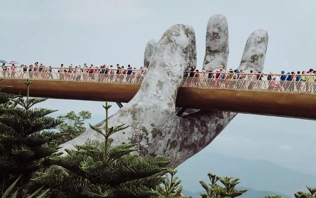 pessoas a passar a Golden Bridge on Ba Na Hills no Vietname 