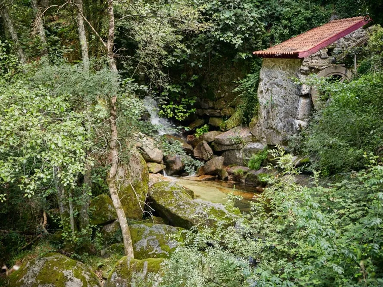 detalhes da aldeia de pontido, com uma casa de pedra e um riacho a descer
