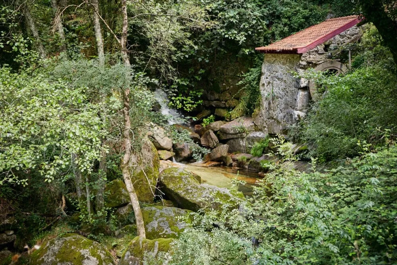 detalhes da aldeia de pontido, com uma casa de pedra e um riacho a descer