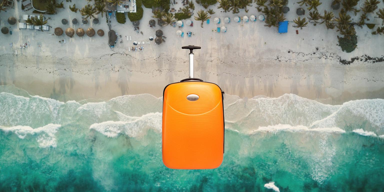 Mala laranja flutuando sobre a praia e o mar azul do México.
