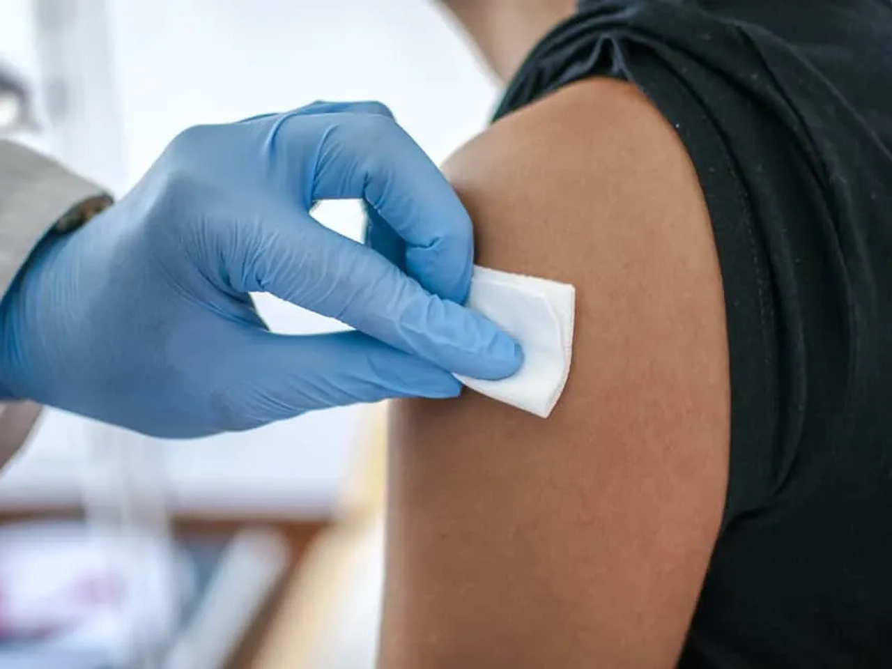 medico a vacinar pessoa