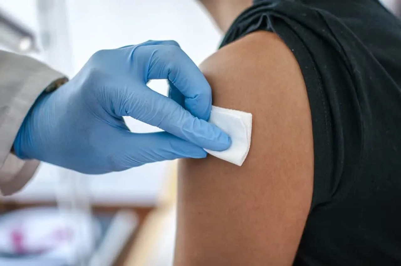 medico a vacinar pessoa