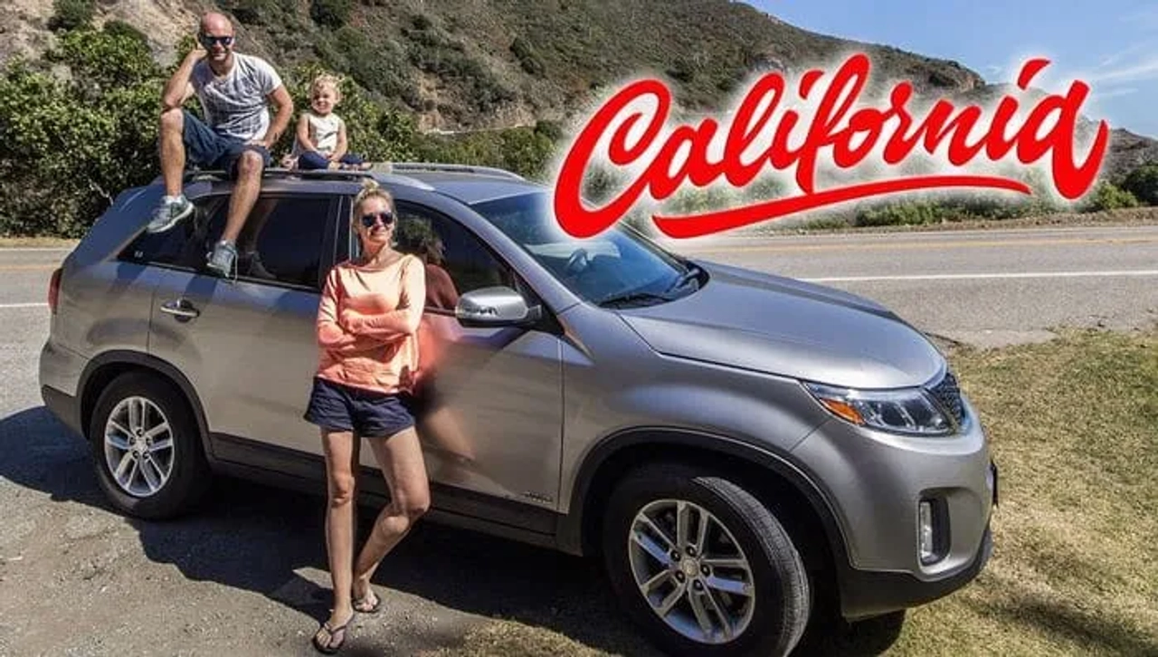 Familia posando junto a un SUV en California, con paisaje natural de fondo.