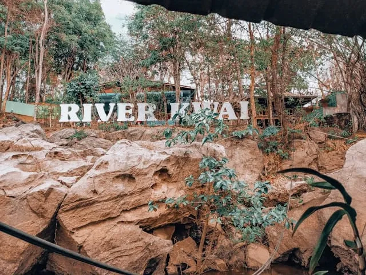 fotografia de letras grandes numa montanha no rio kwai