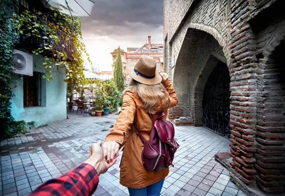 rapariga de costas com mao dada ao namorado que tira foto