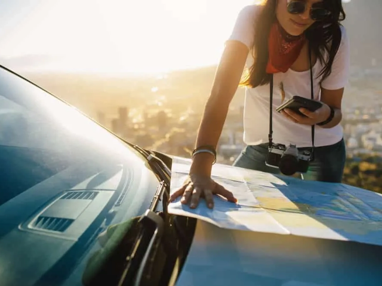 mulher a consultar um mapa em cima de um carro