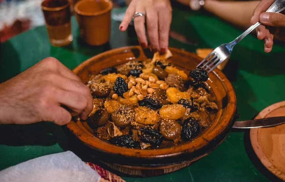Prato típico marroquino sendo compartilhado por duas pessoas.