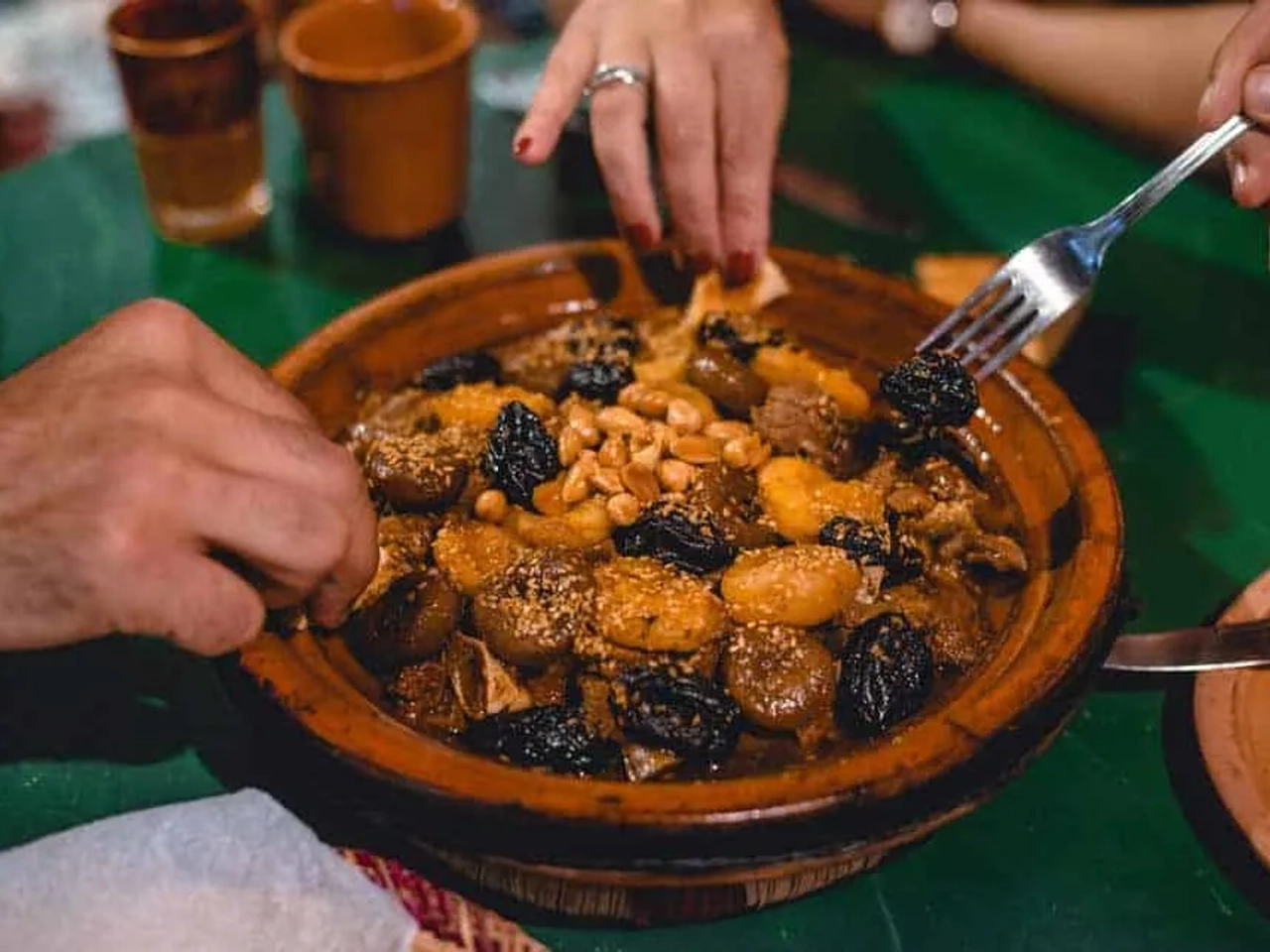 Prato típico marroquino sendo compartilhado por duas pessoas.