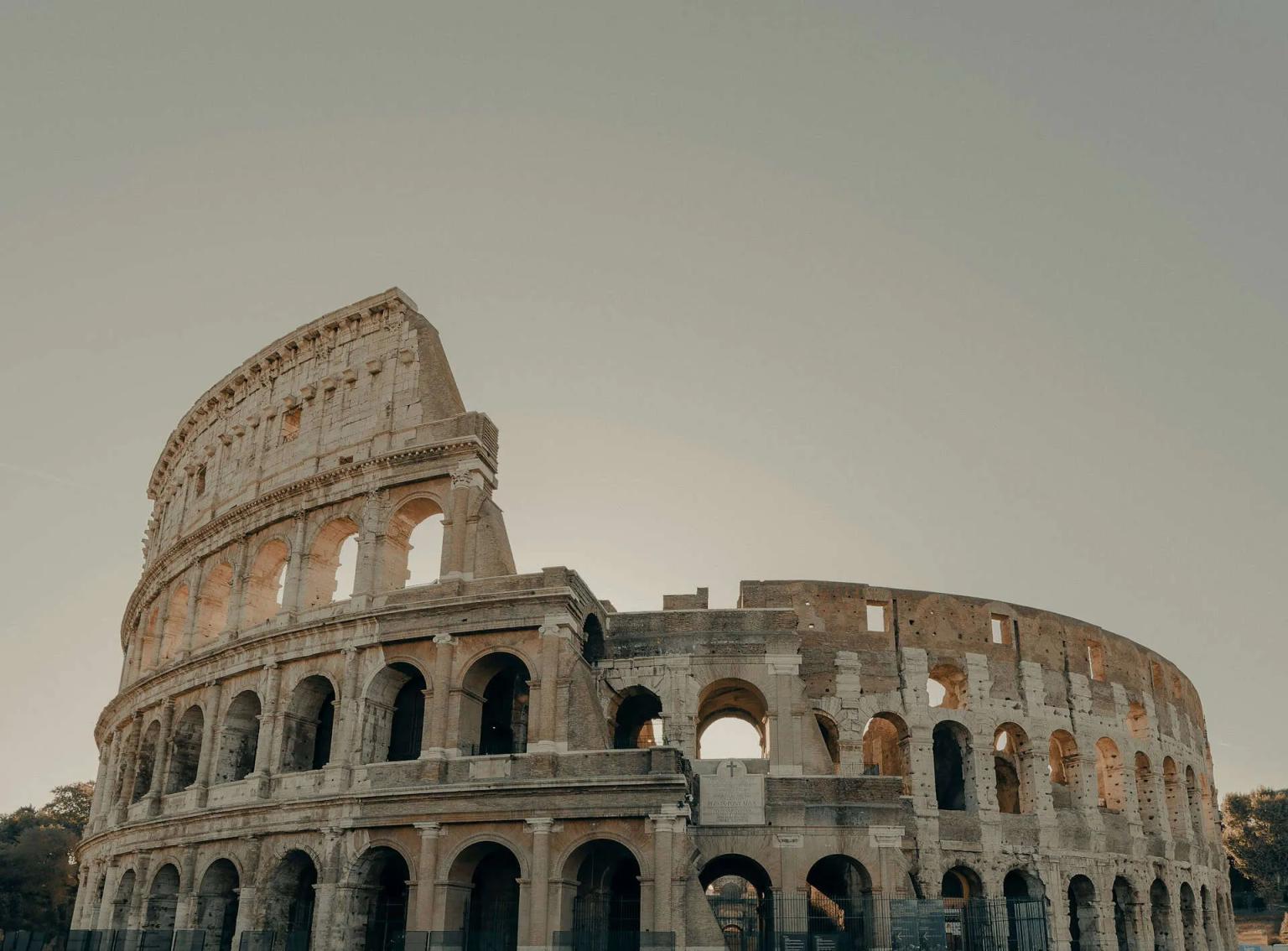 Coliseu romano, icônico anfiteatro, destaca-se na paisagem de Roma.