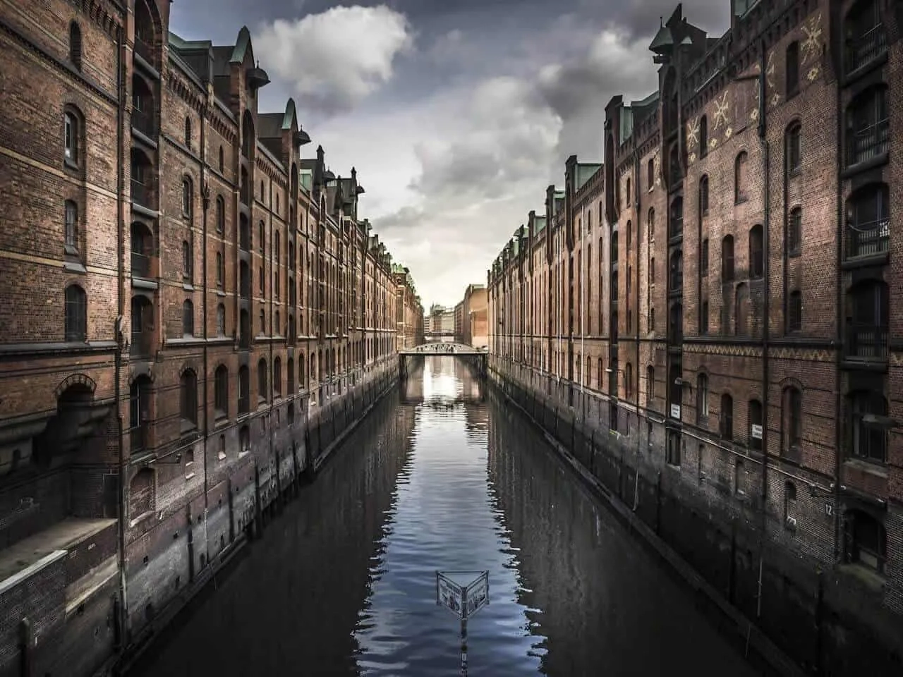 Canal rodeado por armazéns de tijolos em uma cidade alemã.