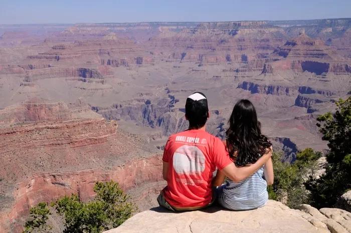 Pareja admirando el paisaje del Gran Cañón desde un mirador.