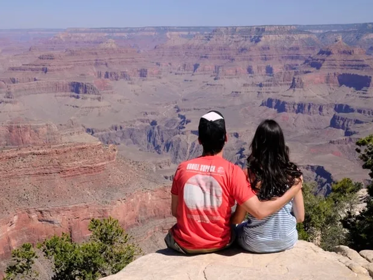 Pareja admirando el paisaje del Gran Cañón desde un mirador.