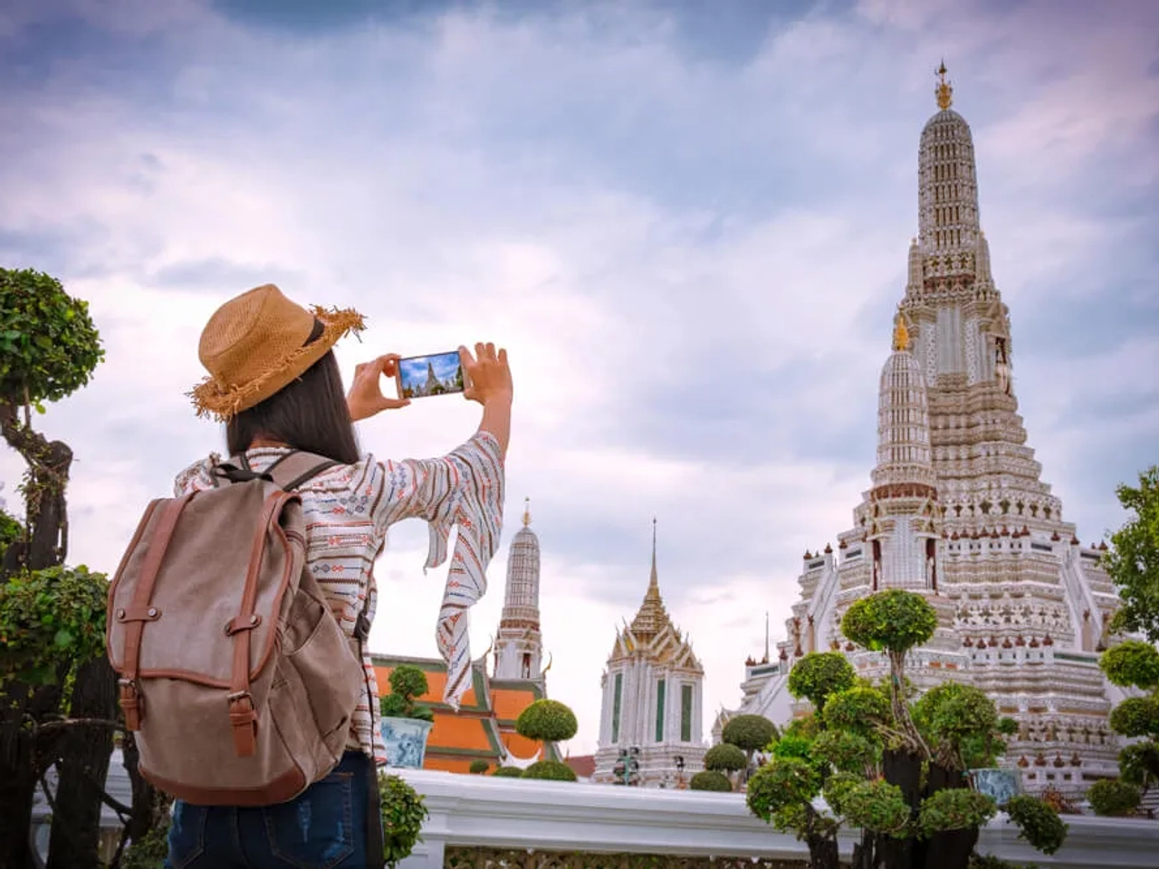 mulher tira fotos a um templo na tailandia