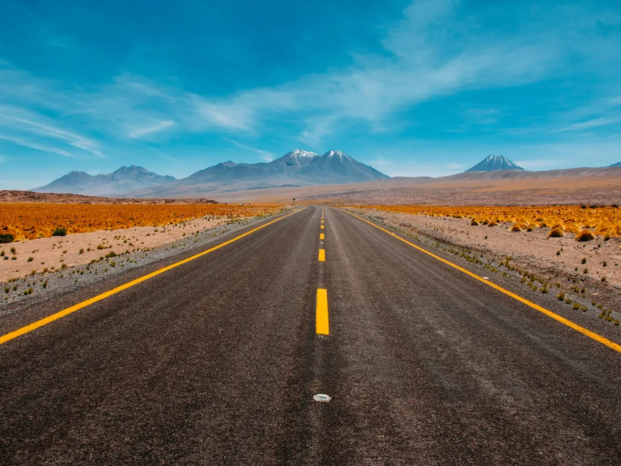 Carretera solitaria en paisaje desértico con montañas