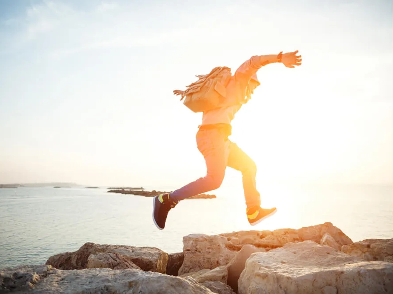 homem a correr pelas montanhas com mochila as costas