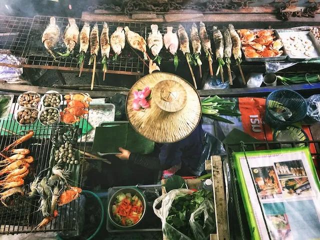 woman cooking in a fodd market in thailand