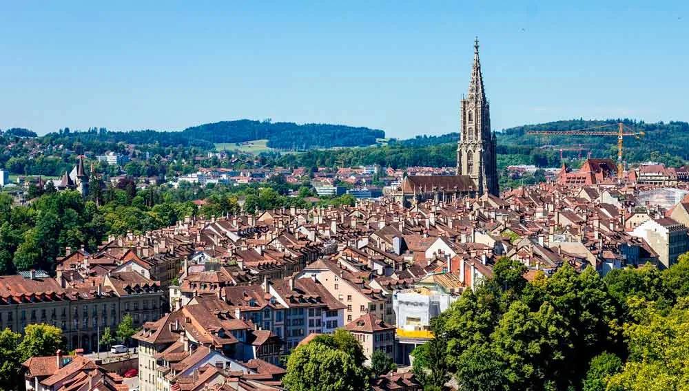Vista panorâmica de Berna, Suíça, com telhados e a torre da catedral.