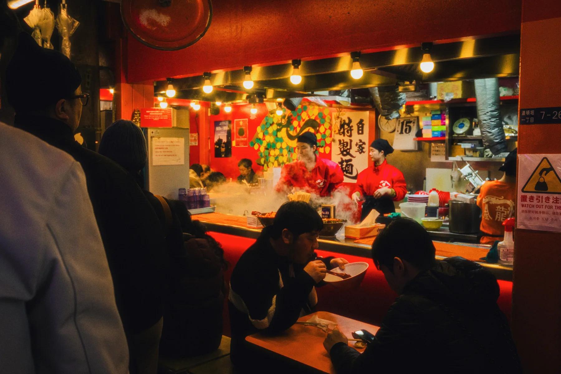 Clienti che mangiano ramen in un locale giapponese, esempio dei costi per mangiare durante un viaggio in Giappone.