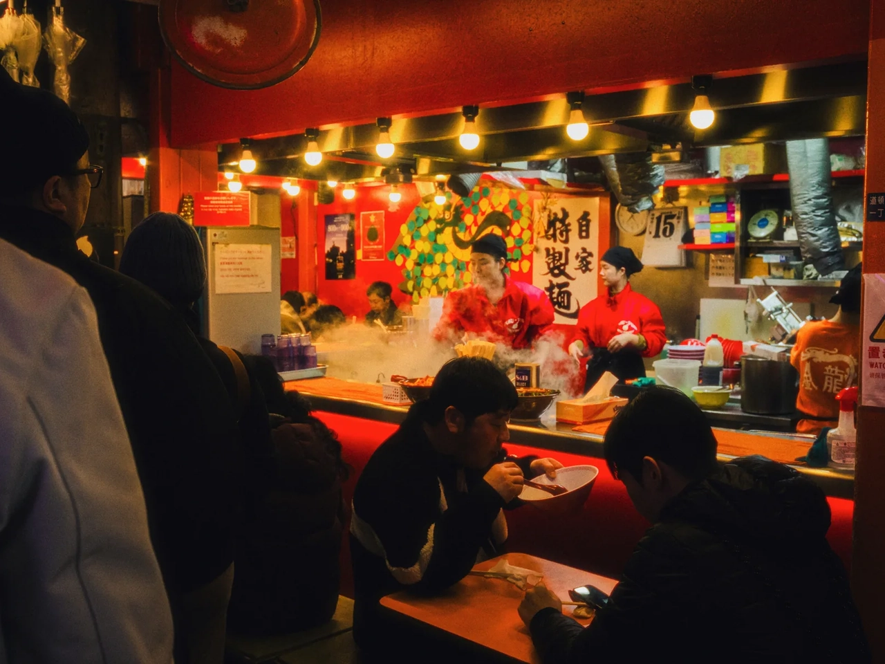 Clienti che mangiano ramen in un locale giapponese, esempio dei costi per mangiare durante un viaggio in Giappone.