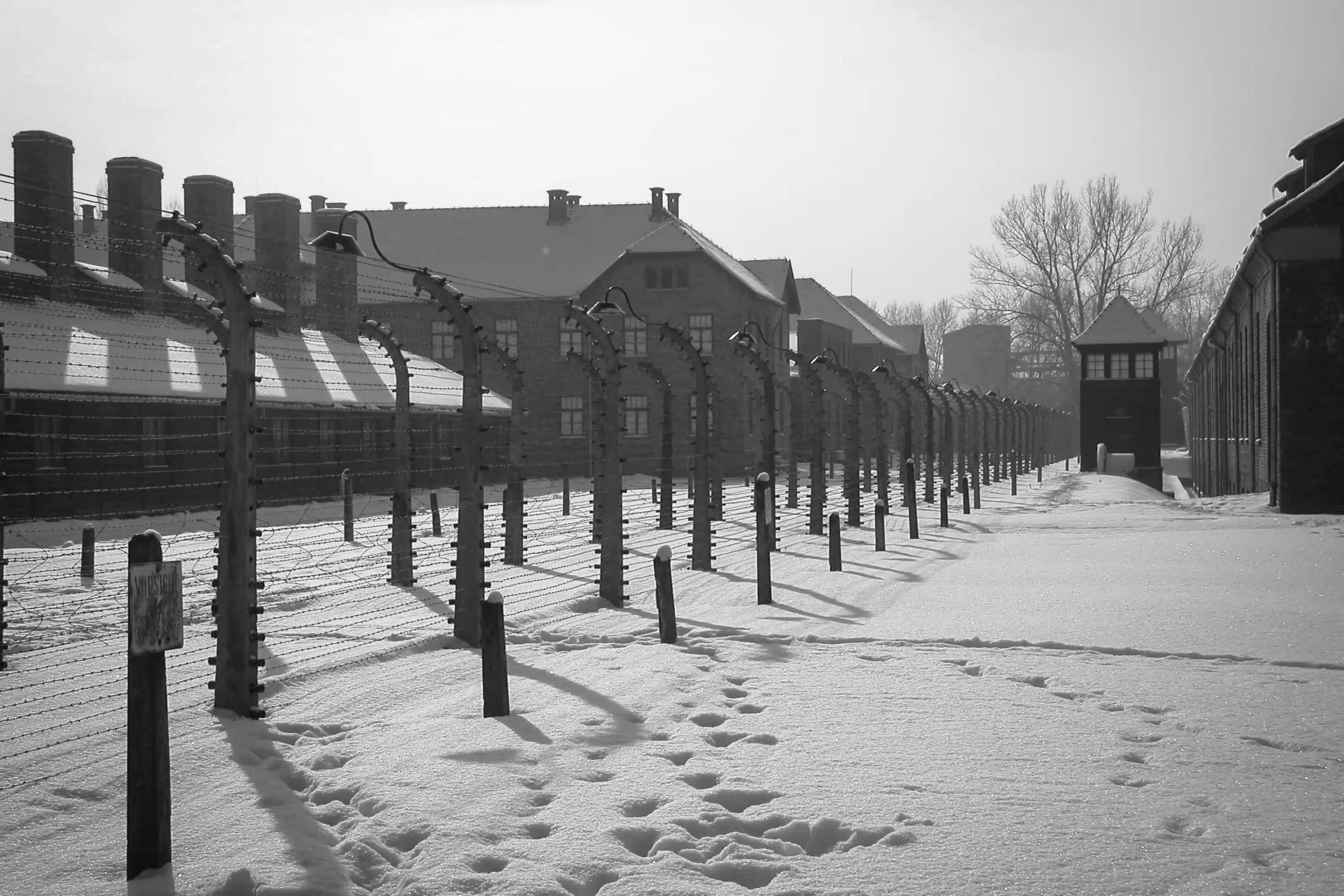 Memorial de Auschwitz-Birkenau, perto de Cracóvia, com neve e barracões históricos.