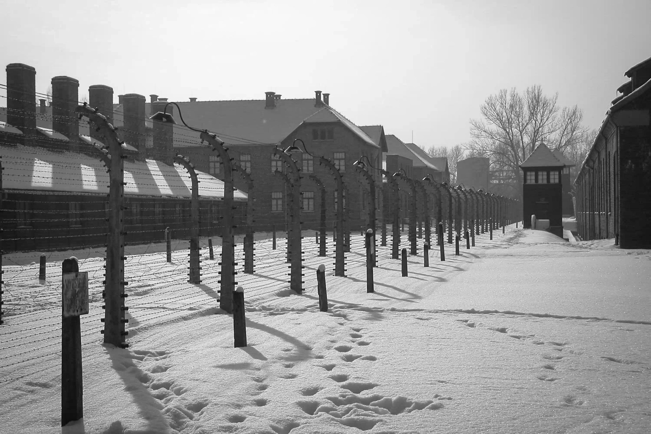 Memorial de Auschwitz-Birkenau, perto de Cracóvia, com neve e barracões históricos.