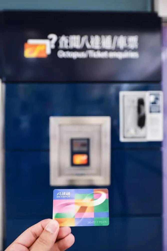 mão a segurar um octupus card para usar nos transportes de hong kong