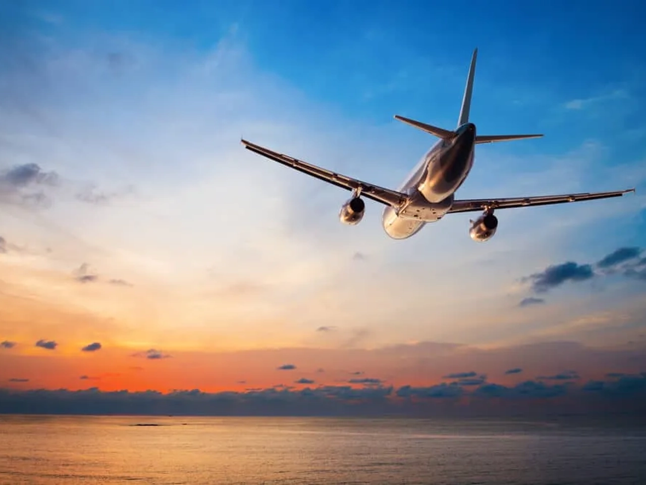 aviao voa em direçao ao por do sol