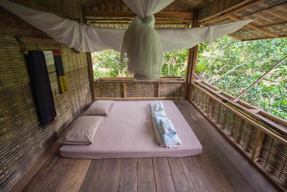 cama numa varanda com mosquiteiro