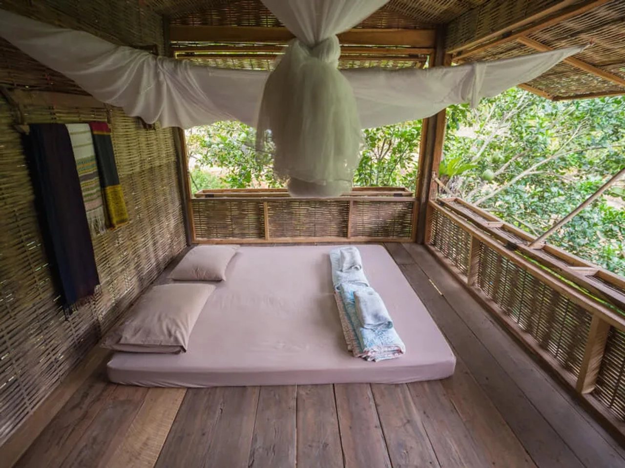 cama numa varanda com mosquiteiro