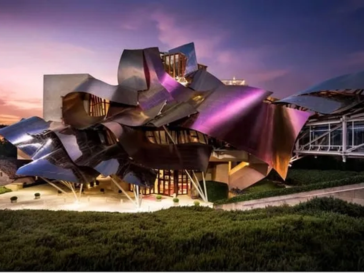 Hotel con diseño arquitectónico innovador y colorido, rodeado de vegetación.