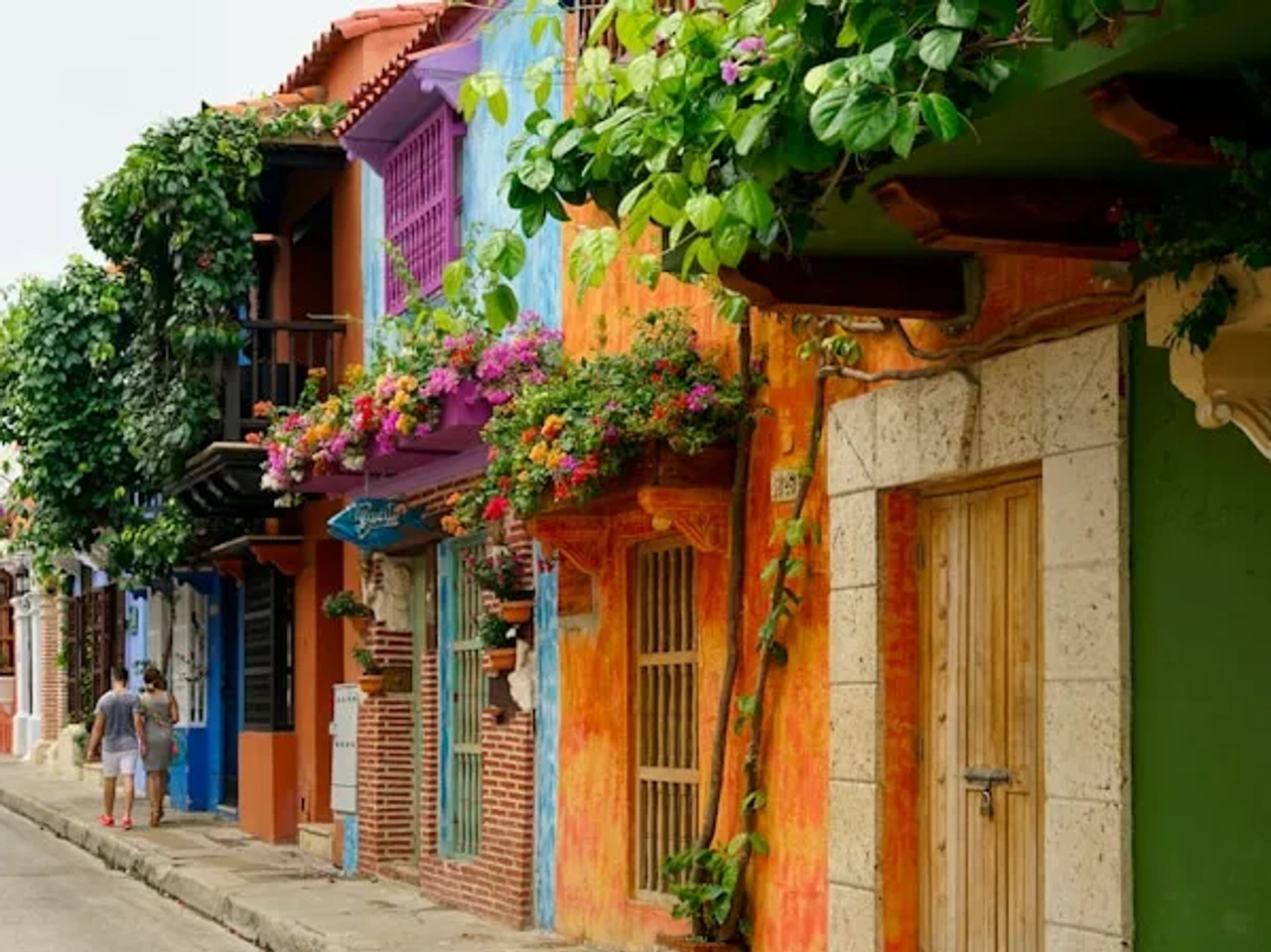 casal a passear numa rua colorida em Cartagena na Colombia