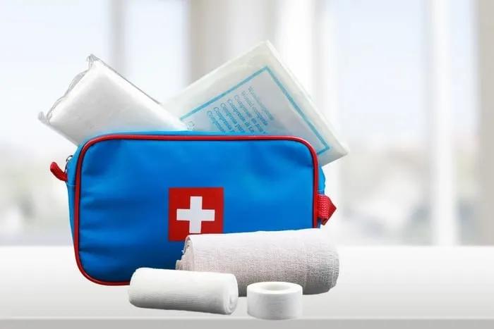 Botiquín de primeros auxilios con vendajes y materiales médicos esenciales.