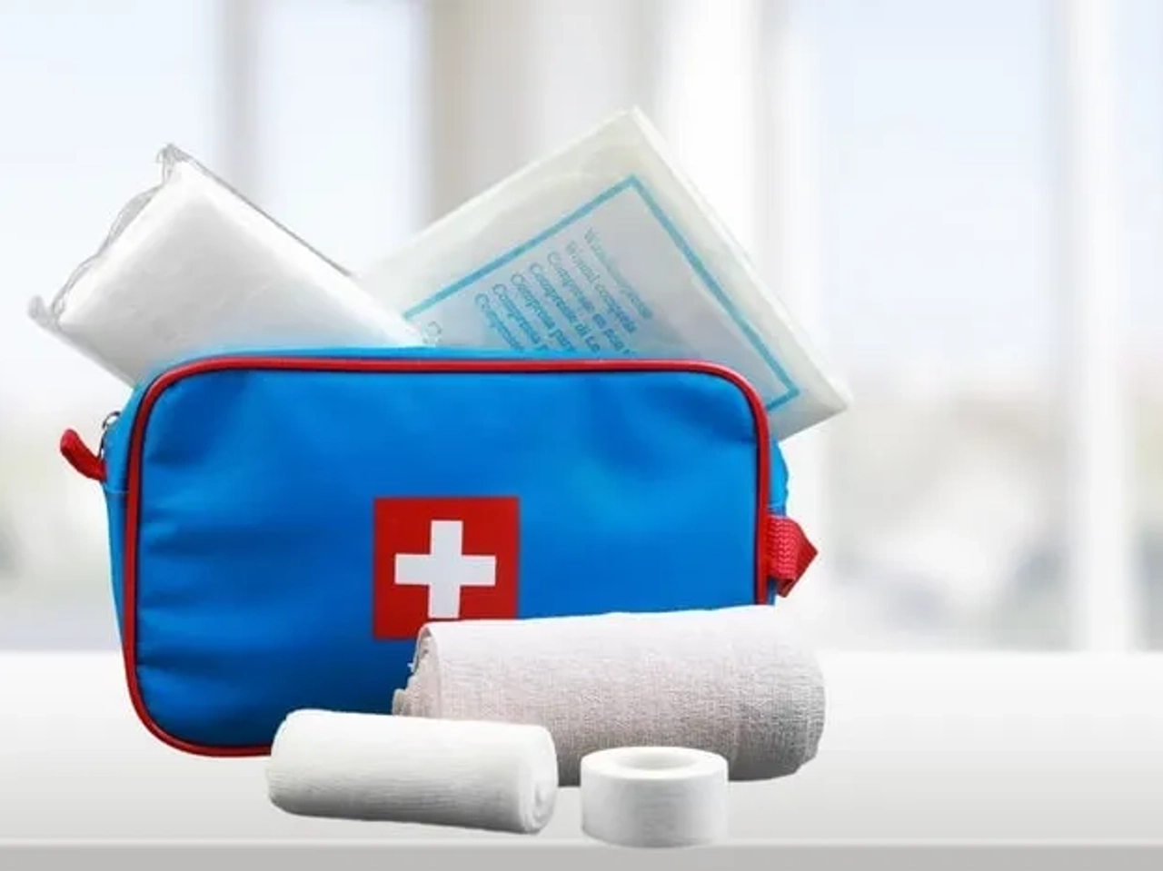 Botiquín de primeros auxilios con vendajes y materiales médicos esenciales.