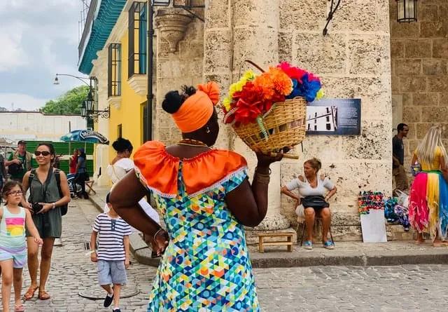 mulher com trajes coloridos e flores em cuba