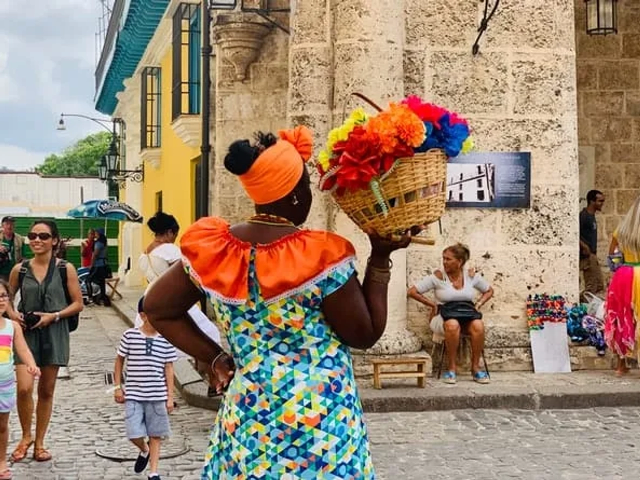 mulher com trajes coloridos e flores em cuba