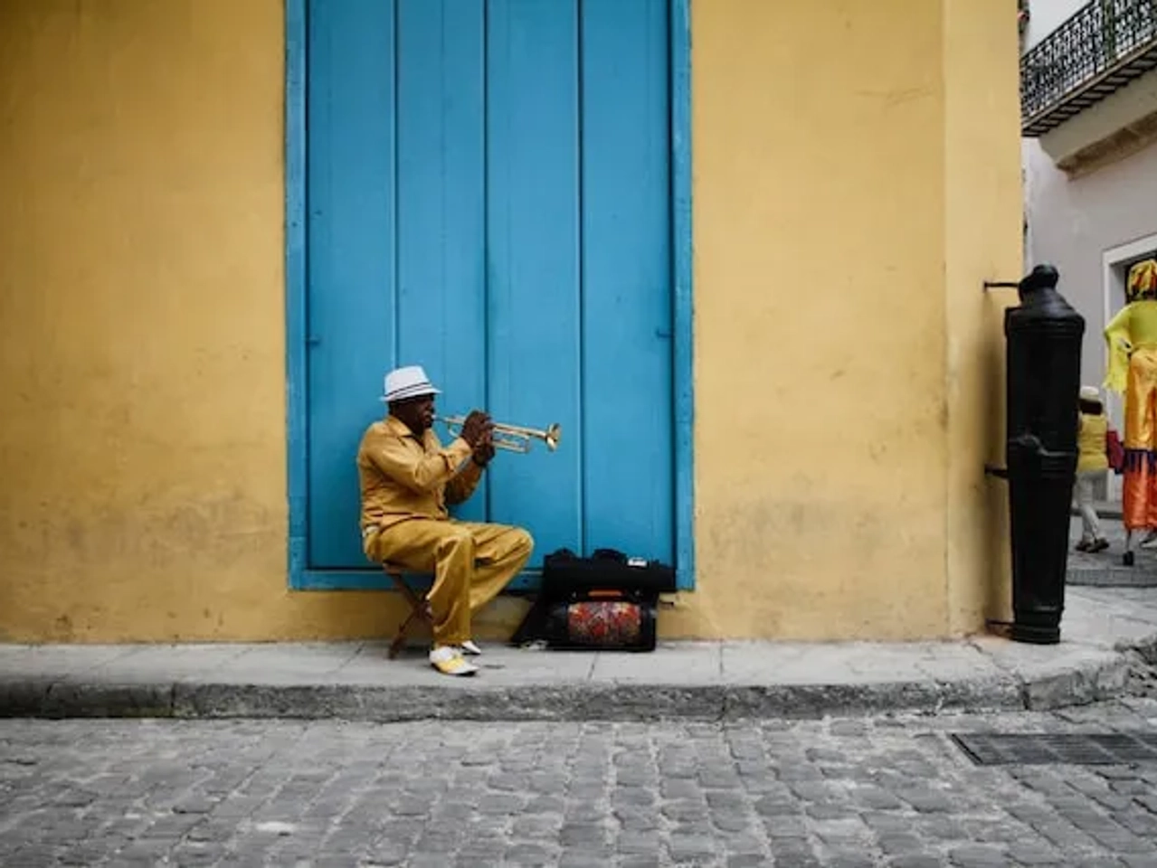 man playing an instrument on a street in cuba