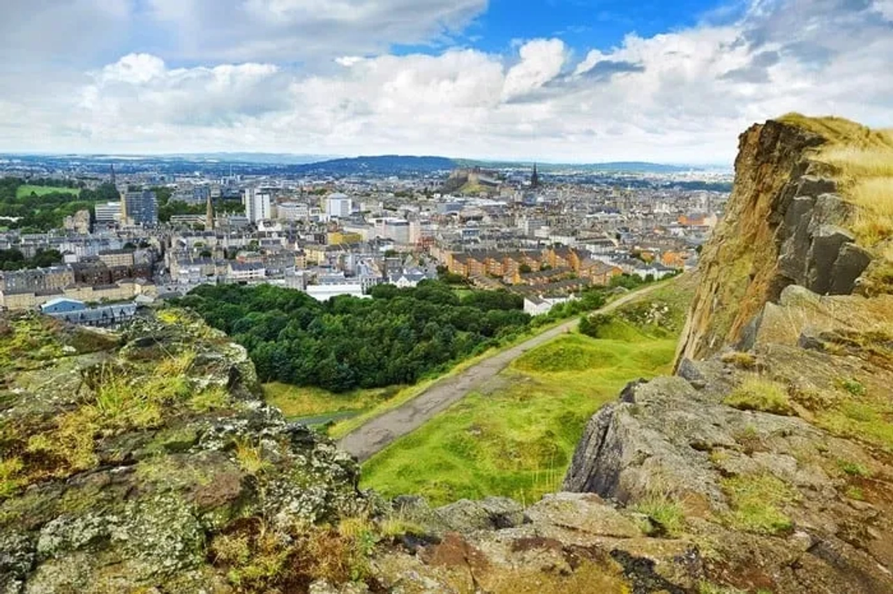 Vista panorâmica de Edimburgo, destacando a cidade e a natureza ao redor.