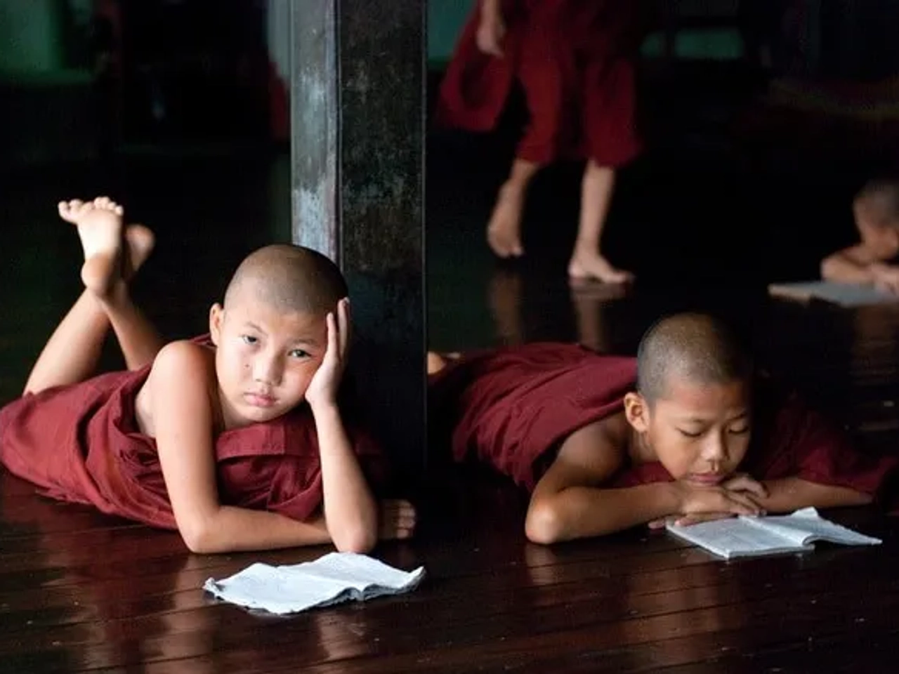 Niños monjes leyendo en un ambiente tranquilo y reflexivo.