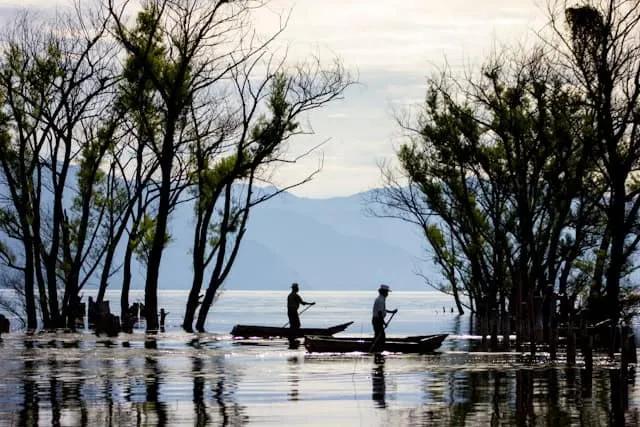 dois senhores um barco a remo no Lake Atitlán, Guatemala